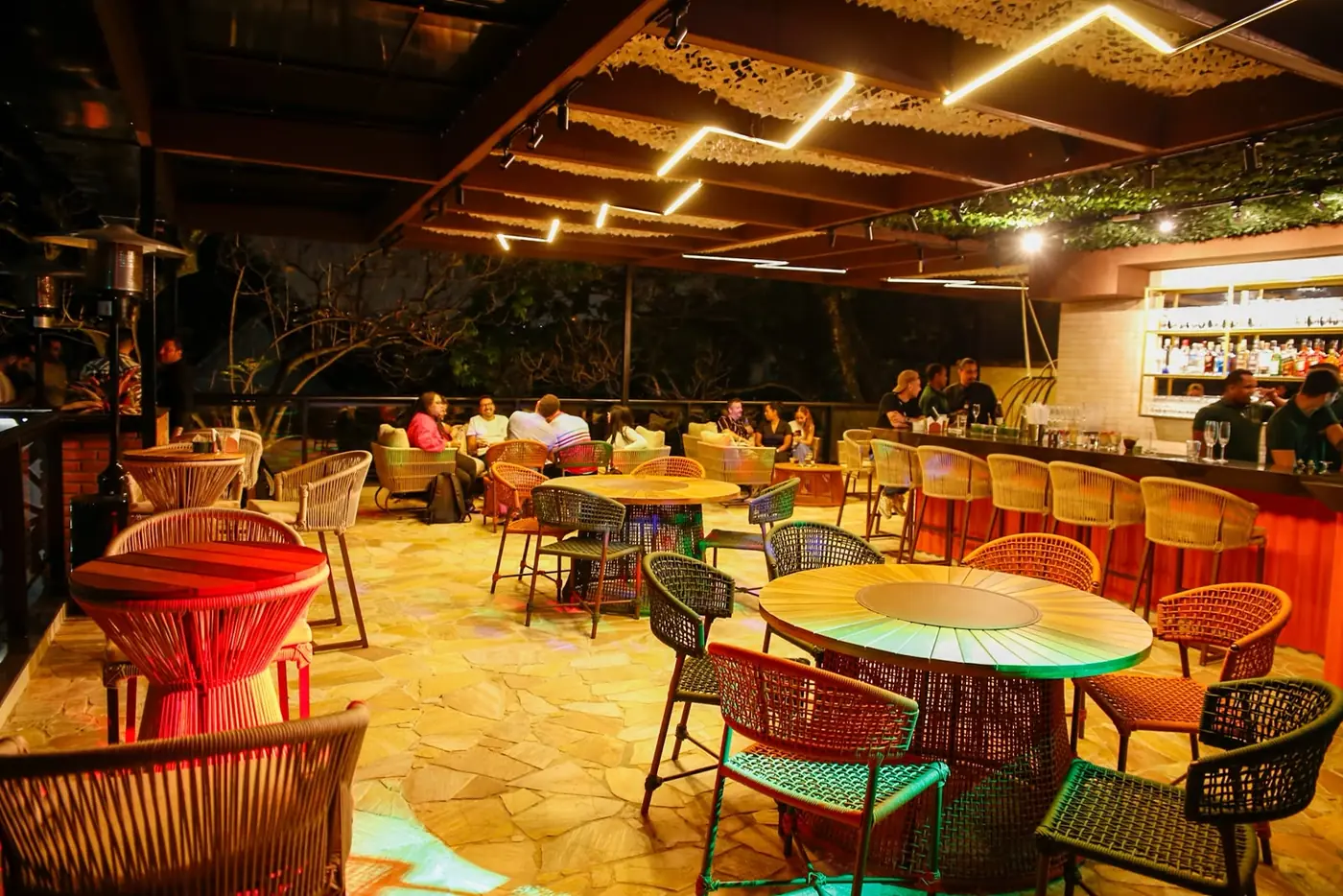 Outro momento do rooftop do Perobah Pinheiros com convidados no bar e nas mesas.